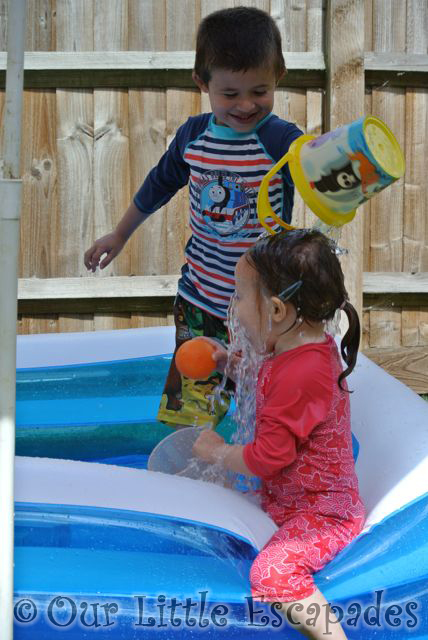 ethan pouring bucket water over little es head