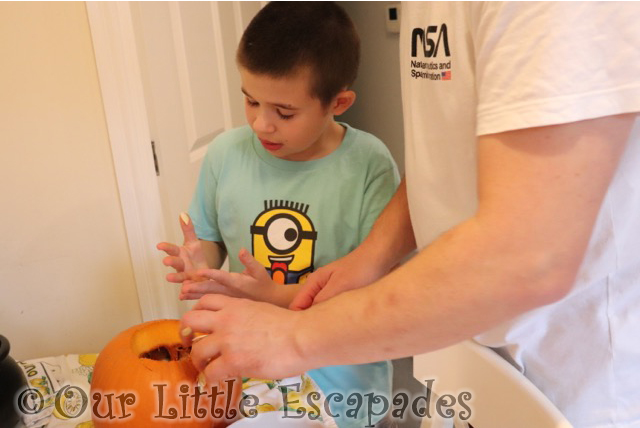 ethan scooping out pumpkin insides carving pumpkins