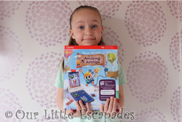 little e holding osmo math wizard amazing airships box