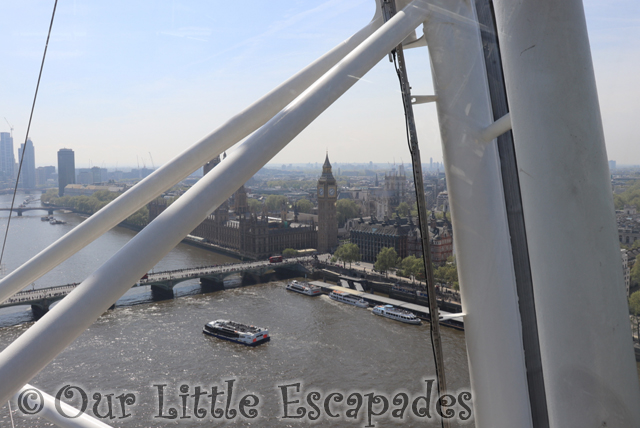 river thames houses parliament through wheel