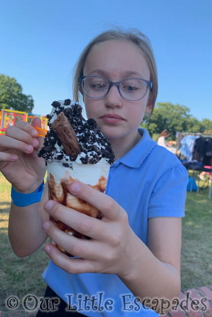 little e holding ice cream sunday covered chocolate sprinkles flake