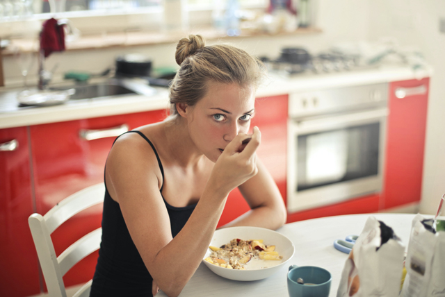 woman in black tank top eating cereals