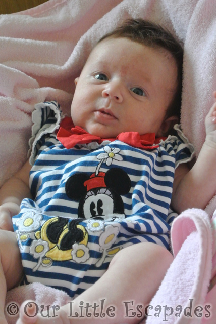 little e wearing minnie mouse striped romper