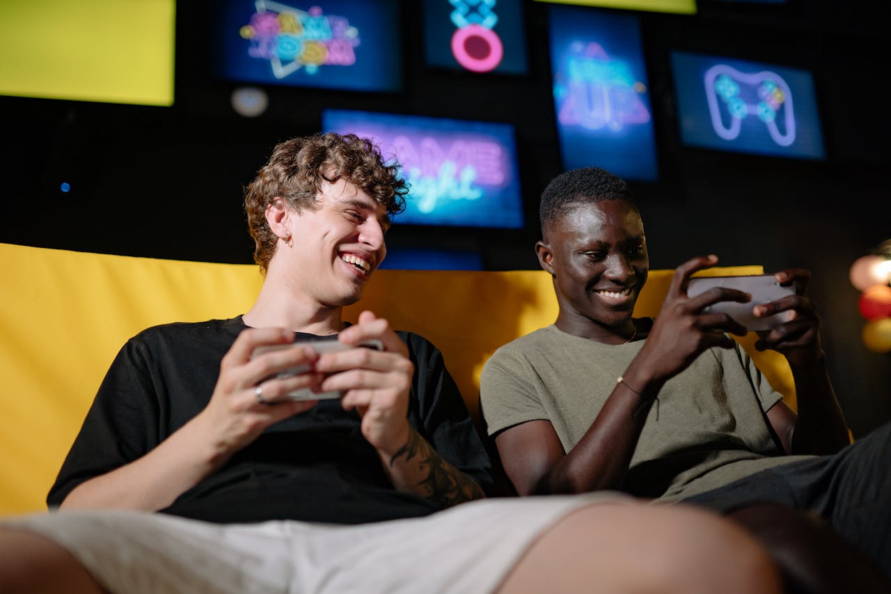 men sitting on the couch while holding their mobile phones