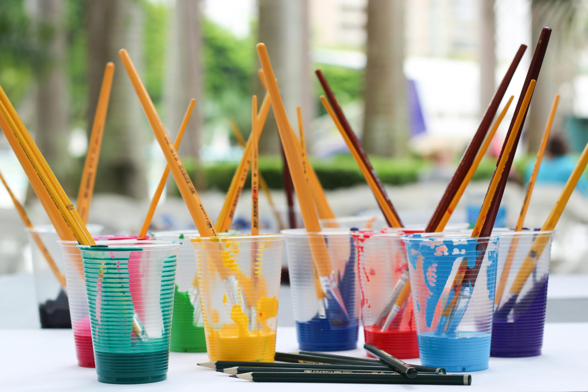 paint brushes inside clear plastic cups